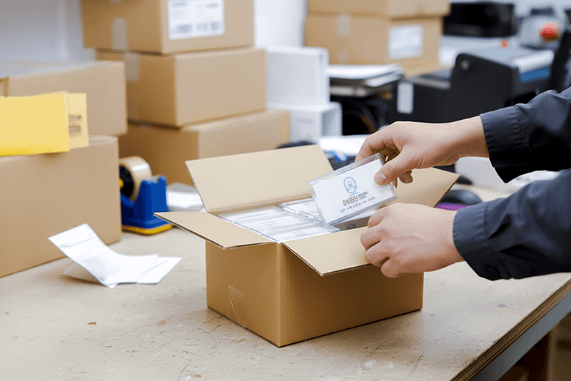 5_센터네트워크_14_직원이 포장된 인쇄물을 박스에 담아 출고를 준비하는 과정, 킨코스의 세심한 포장 작업 장면