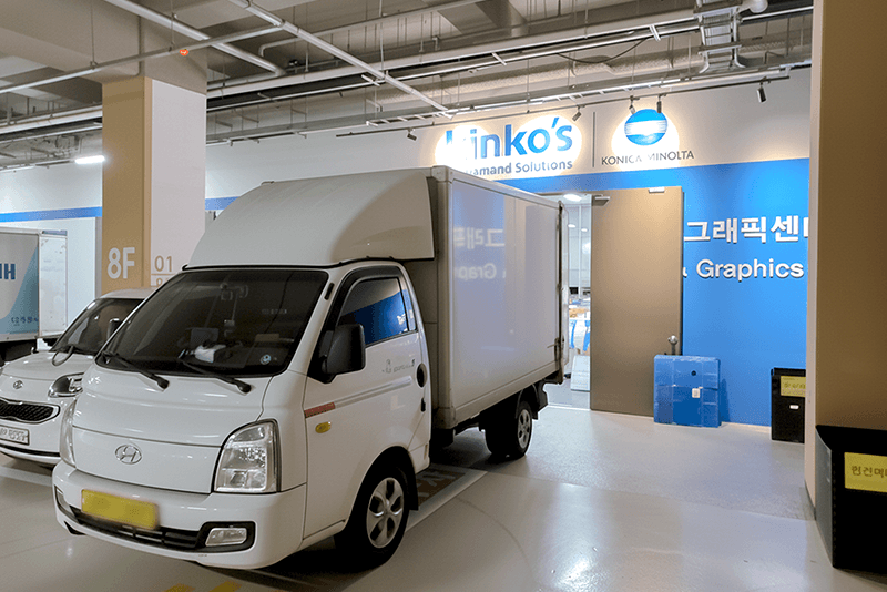 5_센터네트워크_17_킨코스 배송 차량이 물류 센터 앞에 대기 중인 모습, 전국 출고를 위한 전용 배송 차량