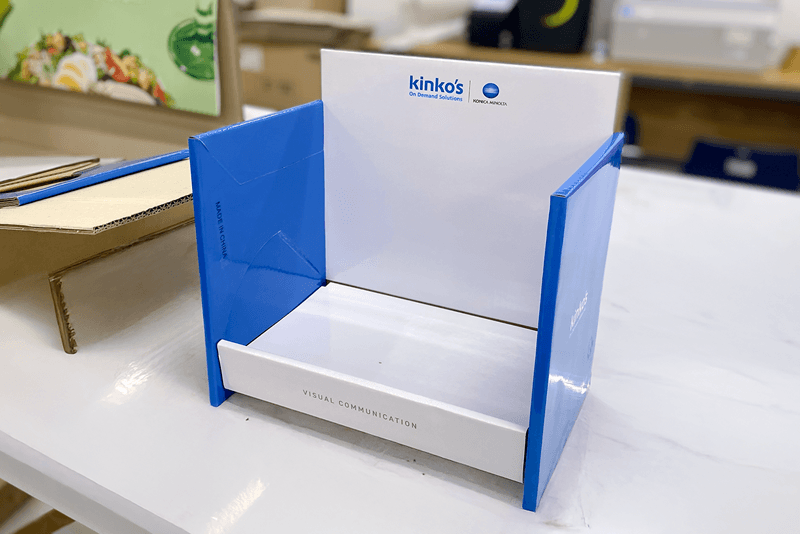 2_포장배송_15_킨코스 로고가 인쇄된 소형 진열대 POP 샘플, 완성된 제작물이 납품 전 품질 검수 중인 모습