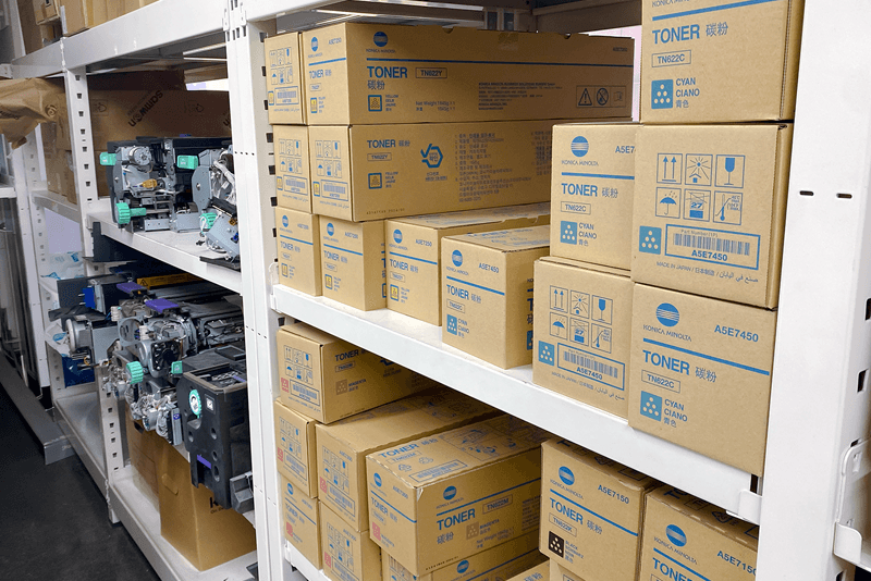 1_생산제작_17_킨코스 생산센터 내 부품 및 토너 보관 창고, 코니카미놀타 토너 박스와 장비 부품이 체계적으로 정리된 모습